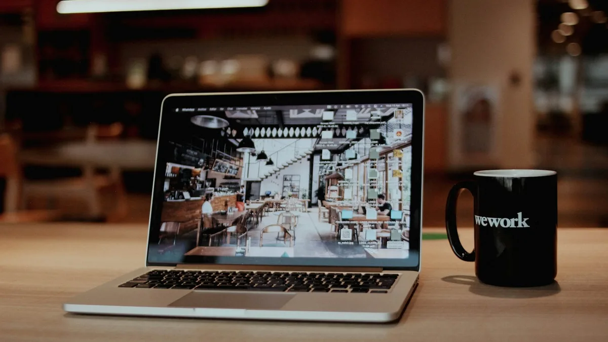 A laptop and coffee mug on a shared workspace table