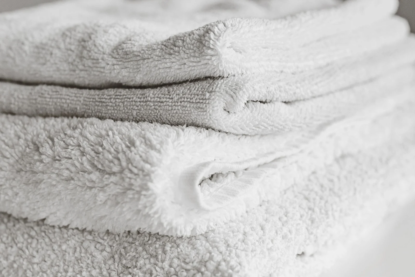 Close-up of folded white towels, illustrating what to ask about before visiting