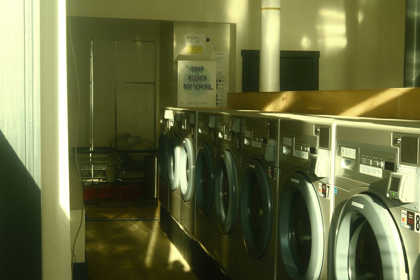 Illustrative stock photograph of front-loading laundry machines; controls and services vary at Korean shops.