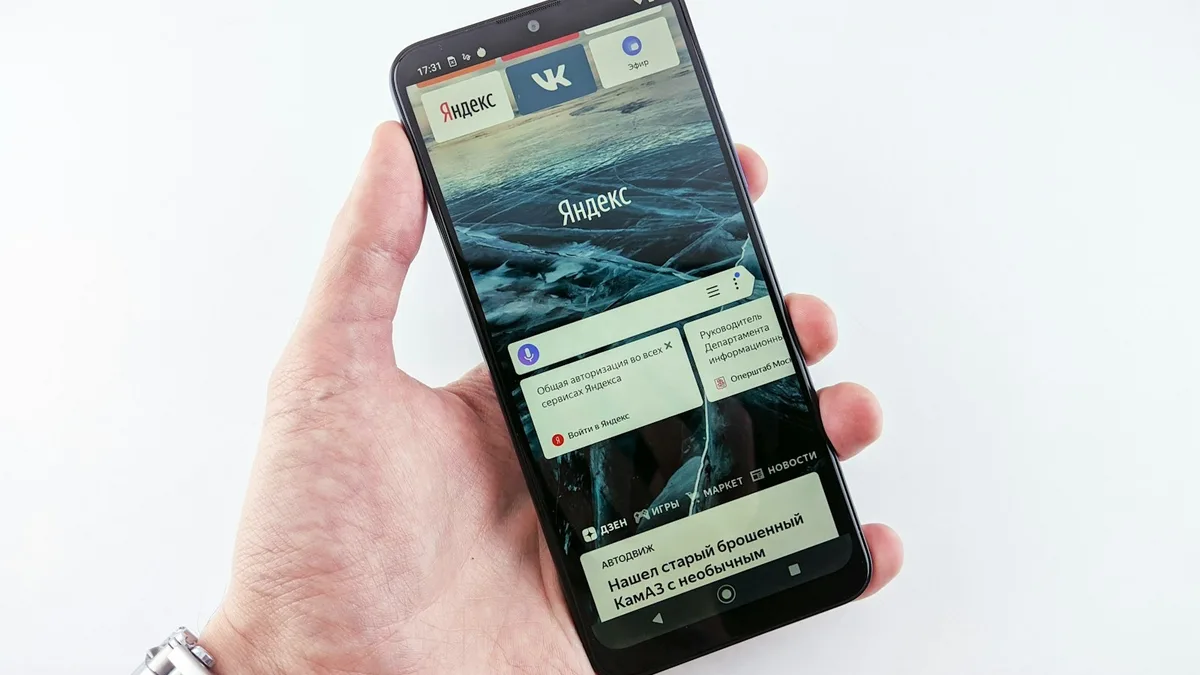 A hand holding a smartphone displaying a weather website