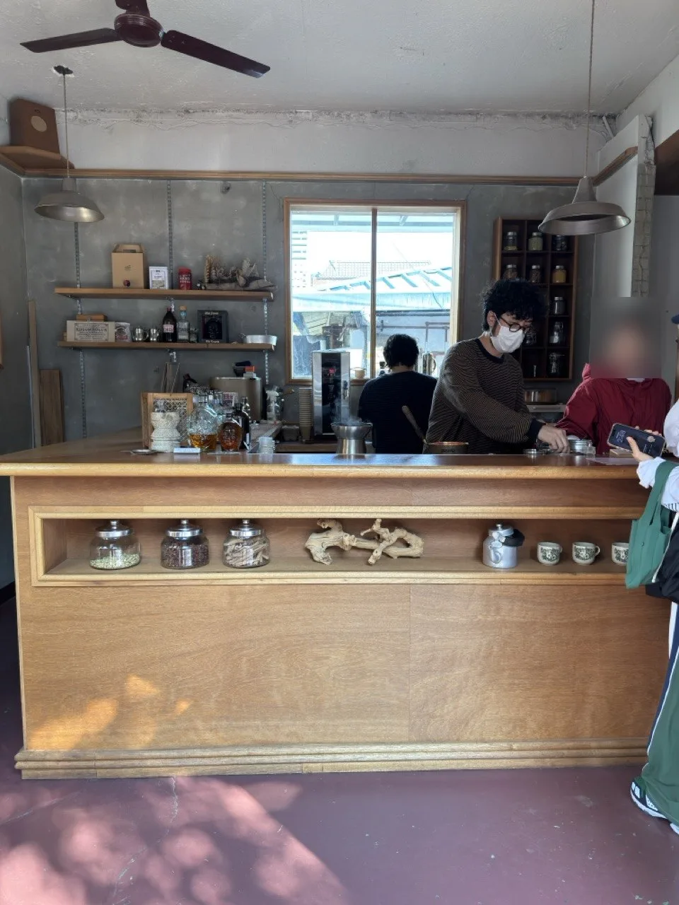 The wooden bar where chai is brewed to order, with spice jars on display. The wooden bar where chai is brewed to order, with spice jars on display.