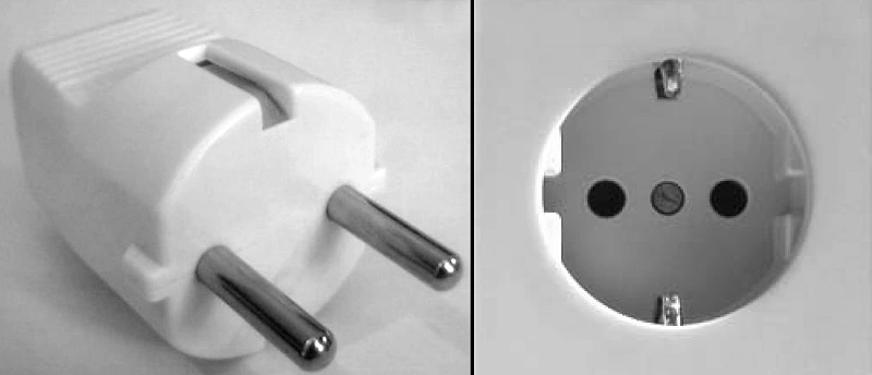 Type F plug beside a matching socket with visible side earthing contacts